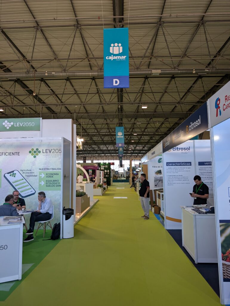 Cartelería colgante doble cara en pasillo principal con lona blockout FR en Infoagro 2025